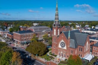 Aerial view of the front of a brick church with a steeple
