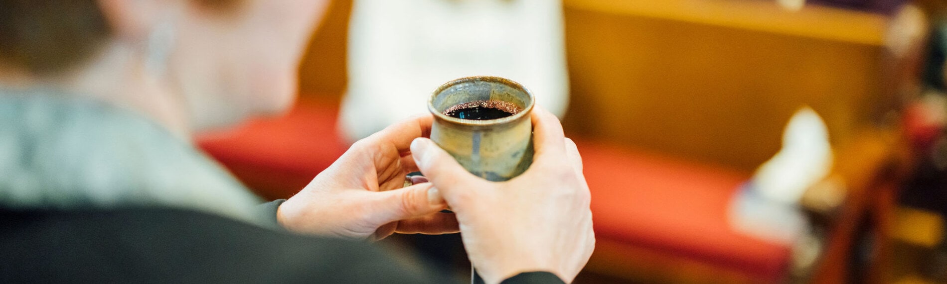 A pair of hands holding a chalice
