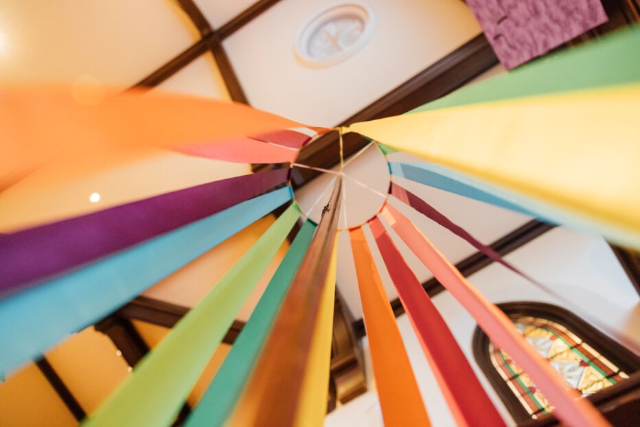 Looking up at a ring from which colored ribbons are hung