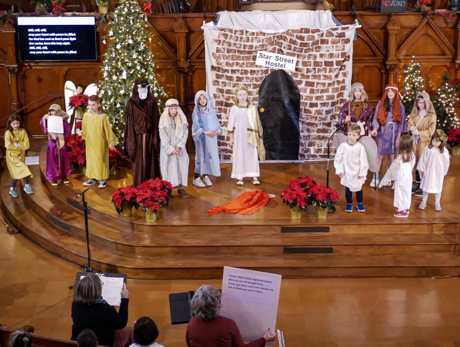 children on a stage performing a Christmas Pageant.